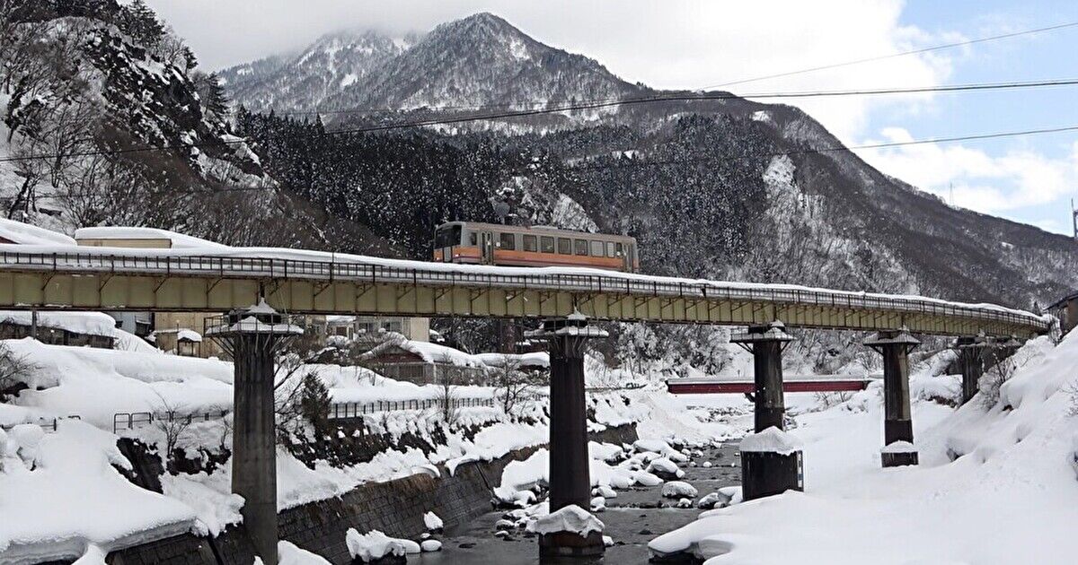 雪の中、大糸線第七下姫川橋梁を走る列車