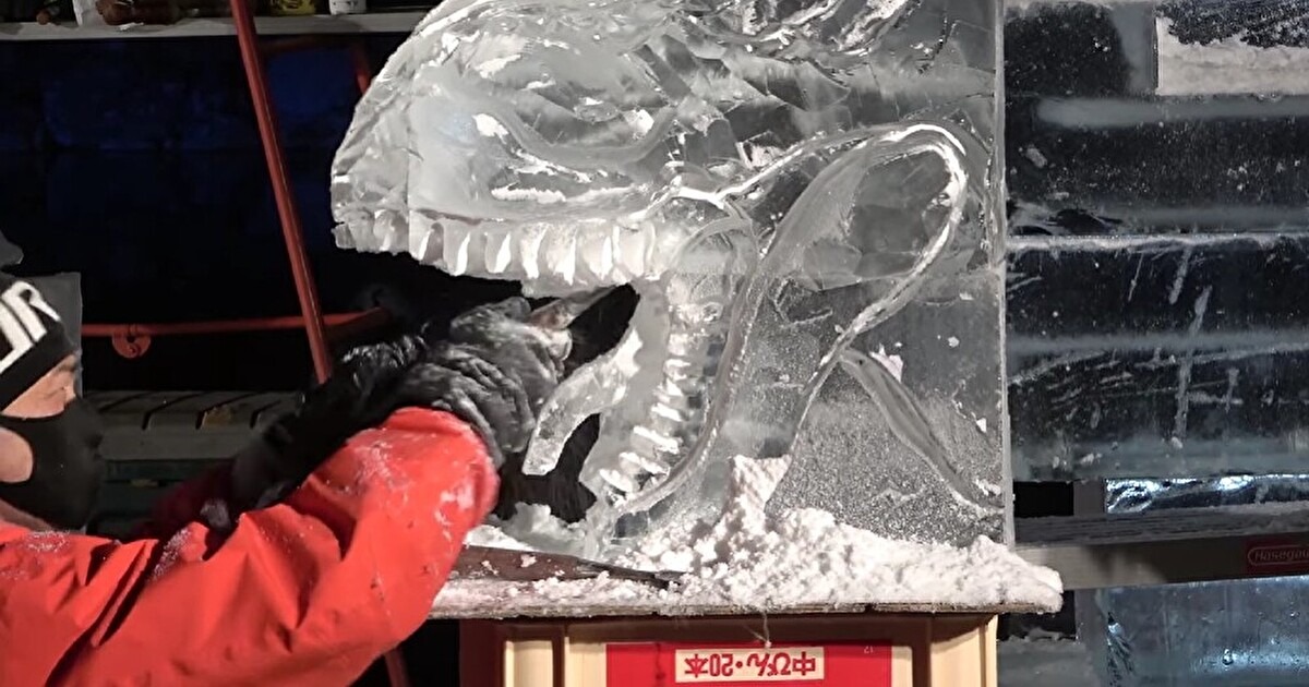 氷を恐竜の形に削る男性