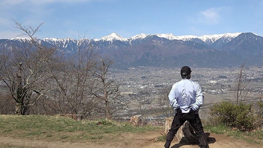 光城山山頂で軽い運動をしながら景色を見る男性